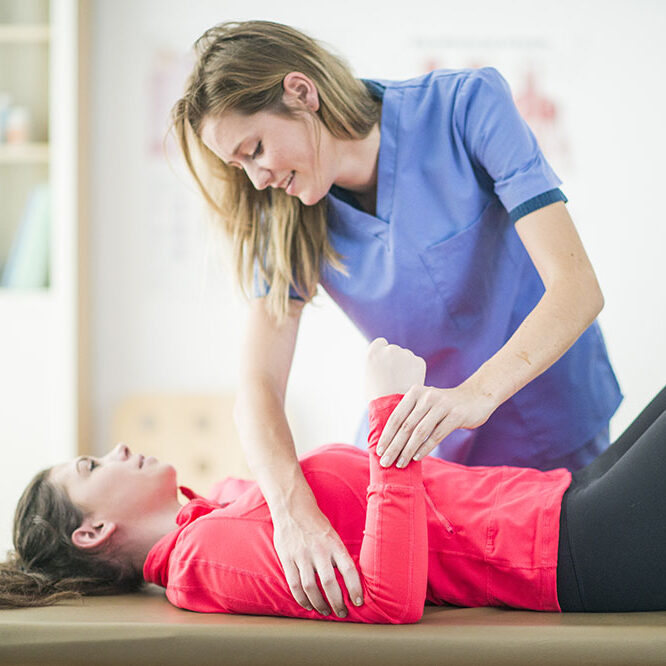 Young girl on the massage table treated by a female therapist